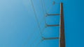 Wooden pole with heavy electrical cables under bright blue sky