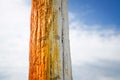 Wooden pole painted orange over the summer sky used for anchoring boats on the seaside