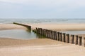 Wooden poles on the beach to break the water