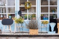 Wooden porch of house with plants and branches yellow mimosa. Facade home with garden tools, pots flowers. Cozy spring decor veran Royalty Free Stock Photo