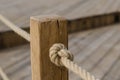 Wooden post. Rope. Knot. Tree structure. Marine rope. Node. Sisal rope. Royalty Free Stock Photo