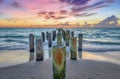 Wooden posts on the sandy beach at sunset. Naples Beach, Florida Royalty Free Stock Photo