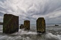 Wooden posts in the shallow ocen water on an overcast day Royalty Free Stock Photo