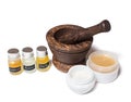 Wooden pounder with bottles of organic oils and