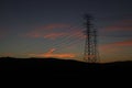 Wooden power pole silhouetted against a picturesque sunset sky, overlooking a rolling hills