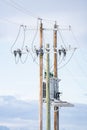 Wooden power poles standing tall against a blue sky with transformers and power lines in Rural Alberta Canada Royalty Free Stock Photo