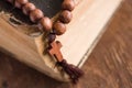 Wooden prayer beads with a Christian cross lie on the holy bible book on a wooden background. Royalty Free Stock Photo