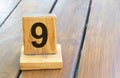 Wooden priority number 9 on a plank tab