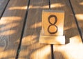 Wooden priority number 8 on a plank table