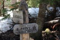 A wooden privy and hitchrack signpost on the Wild Basin Trail in Rocky Mountain National Park, Colorado
