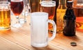 A wooden pub counter, focus on an empty frosty mug of beer Royalty Free Stock Photo