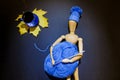 Wooden puppet doll holds a ball of blue yarn and crochet hook in its hands, and wears a knitted winter hat Royalty Free Stock Photo