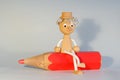 Wooden puppet sitting on a dummy color pencil Royalty Free Stock Photo