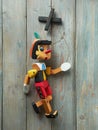 A wooden puppets walk sideways against a rustic wooden background