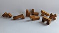 A wooden puzzle box with various wooden pieces inside. The box has a rectangular shape and is made of dark wood.
