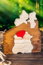 Wooden puzzle in the form of a family of handmade bears on the background of the forest