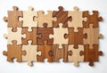 Wooden puzzle pieces arranged on white background. Different shades of wood create diverse pattern. Puzzle pieces are in grid Royalty Free Stock Photo