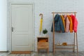 Wooden rack with warm jackets in hallway