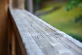 Wooden railing on the terrace outside. Detail on wood. Green landscape in the background