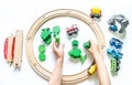 Wooden railway. A boy plays a toy train. Flat lay