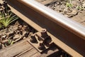 Wooden railway sleeper. Rails fastened with screws to the railway sleeper