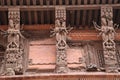 Wooden reapers with elegant carvings of god and and goddess placed in an angles to support the slopped roof of the building in