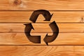 Wooden recycling logo on wooden background. Recycling arrows carved in wood. Sustainable energy, ecological concept. AI generated.