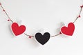 Wooden red and black hearts on twine rope garland isolated on a white background. Minimal Valentine`s Day or wedding party decorat Royalty Free Stock Photo