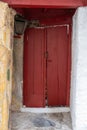 Wooden red color entrance door, locked closed. Traditional house facade, old town of Plaka, Athens Greece Royalty Free Stock Photo