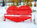 Wooden red heart-shaped bench in the park in winter Royalty Free Stock Photo