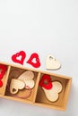 Wooden red hearts decorations stuff for gifts twine in cardboard holder light background. Eco set for Valentine's Day Royalty Free Stock Photo