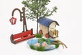 Wooden red park bench maquette and Light bulb, small lake, caravan, plantain Royalty Free Stock Photo