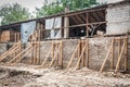 Wooden reinforcement beams holding old brick wall of the destroyed and damaged house collapsed in the earthquake or other natural Royalty Free Stock Photo