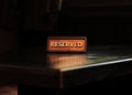 Wooden reserved sign with capital letters on dining table in restaurant