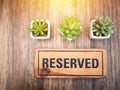 Wooden reserved sign on top of a wooden table in a restaurant, R