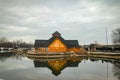 Wooden restaurant near the frozen pond in sunset, winter cloudy day Royalty Free Stock Photo