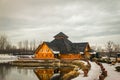 Wooden restaurant near the frozen pond in sunset, winter cloudy day Royalty Free Stock Photo