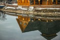 Wooden restaurant near the frozen pond in sunset, winter cloudy day Royalty Free Stock Photo