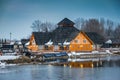 Wooden restaurant near the frozen pond in sunset, winter cloudy day Royalty Free Stock Photo