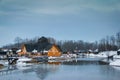 Wooden restaurant near the frozen pond in sunset, winter cloudy day Royalty Free Stock Photo