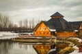 Wooden restaurant near the frozen pond in sunset, winter cloudy day Royalty Free Stock Photo