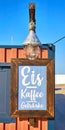Wooden restaurant sign on the beach. Letter with Kaffee Eis GetrÃÂ¤nke means Coffee Ice Drinks