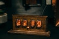 Wooden retro Nixie lamp indicator clock in dark room