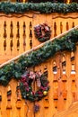 Wooden Retro Restaurant Building Decorated of Artificial Fir Tree with Lighting Garland and many Red Christmas Bells at Winter Day Royalty Free Stock Photo