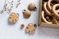 Wooden rings and beads in craft box, monstera clips for baby teether on white background. Natural wood toy for child. Eco-friendly