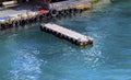 Wooden river pier for small boats with used tires as bumpers