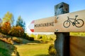 A wooden road sign showing a direction for a mountainbike path. A sunny autumn day for a bike tour through the nature. Royalty Free Stock Photo