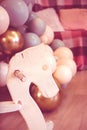 Wooden rocking horse on the background of festive colorful balls