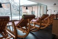 Wooden rocking lounge chairs face snowy mountain view