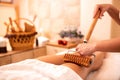Wooden roller with extended handle applied in body massage